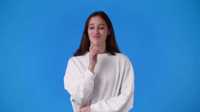 一个女孩在蓝色背景上打手势的4k慢动作视频。