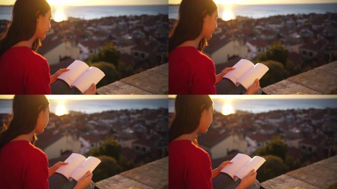 日落时在壁架上看书的年轻女子