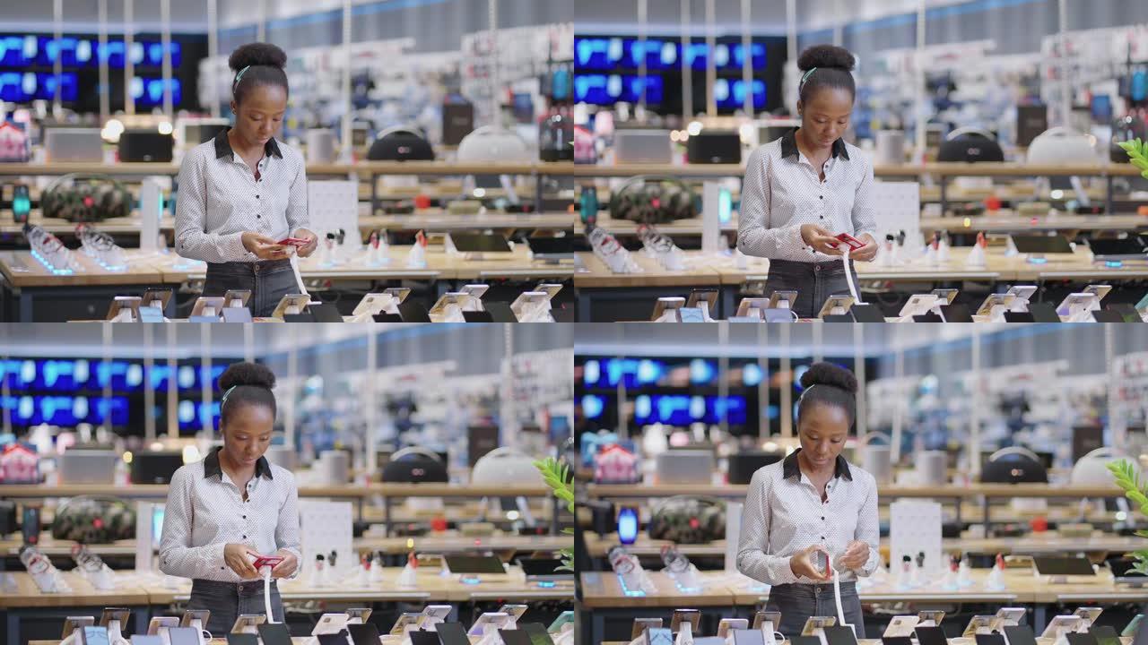 黑人女性购物者正在电子商店观看现代手机的展览样本，女士正在零售店购买智能手机
