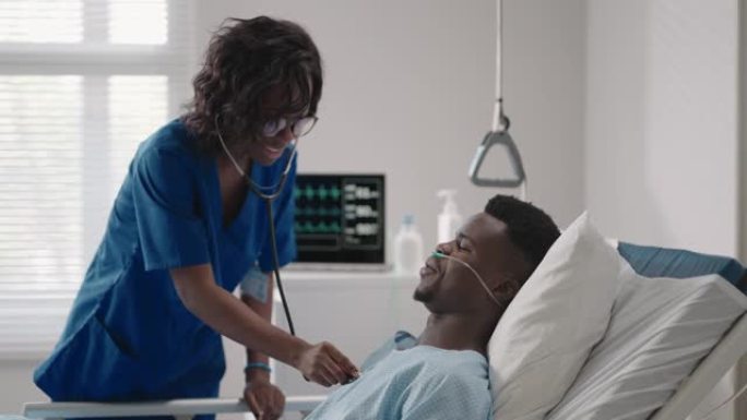 一名黑人女医生正在与一名躺在医院病床上并与酸供应相连的黑人男性患者交谈。