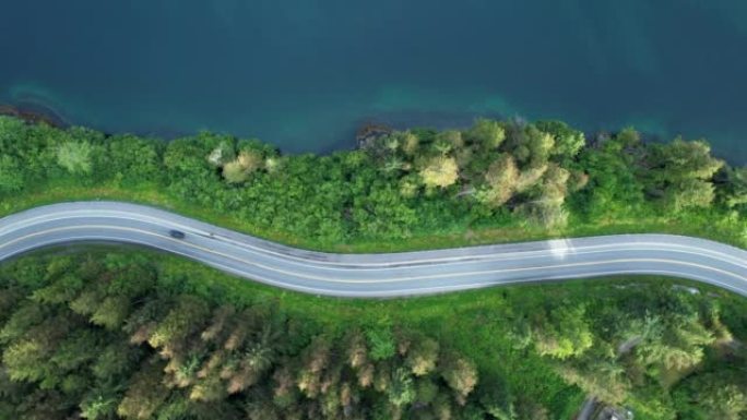 空中无人机拍摄了在湖边的道路上行驶的车辆