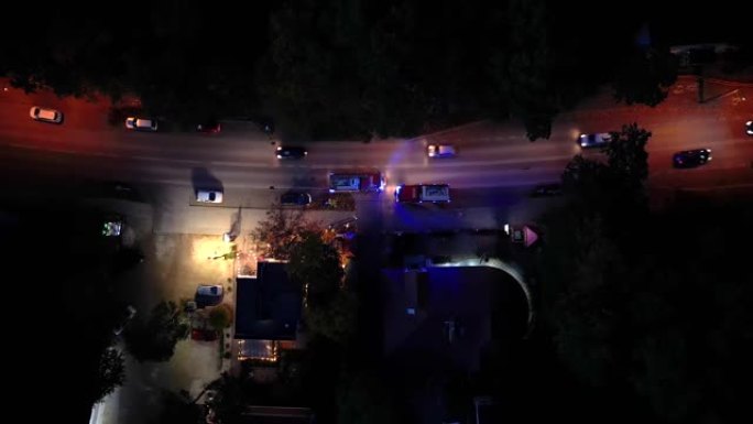 一个消防队鸣笛并冲过交通的空中射击。晚上穿过十字路口的消防车。消防车工作人员。空中