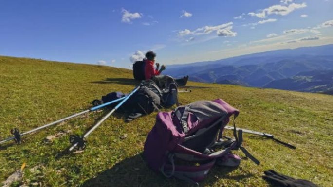 SLO MO女徒步旅行者坐在阳光明媚的山坡上放松身心