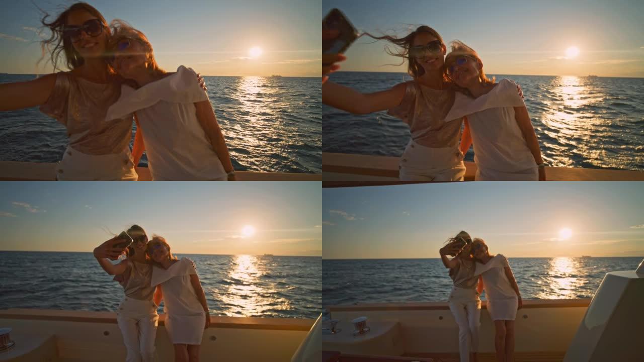 SLO MO DS两名妇女在日落时在游艇上自拍照