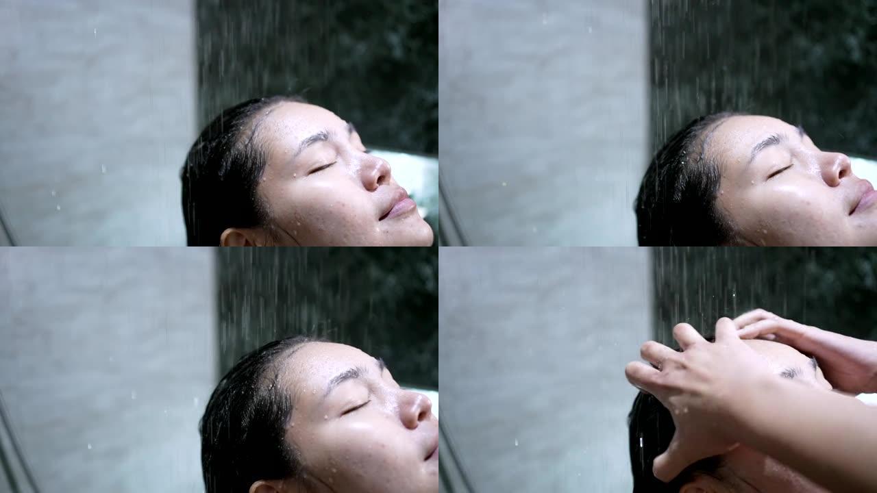亚洲女孩她正在雨滴淋浴中洗澡