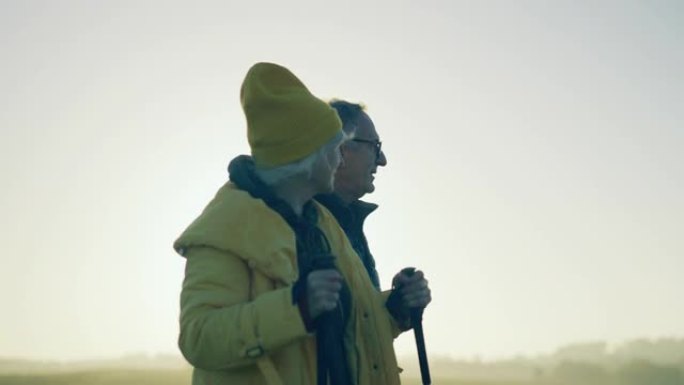一对年长的情侣在乡下散步。北欧步行