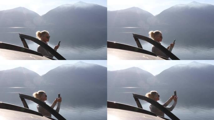 女人在风景秀丽的湖景旁拍照
