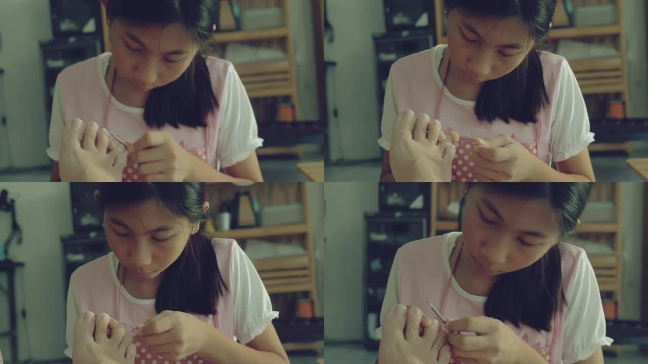 亚洲女孩在家里用指甲锉把母亲的指甲脚趾涂在地板上，周末概念水疗。