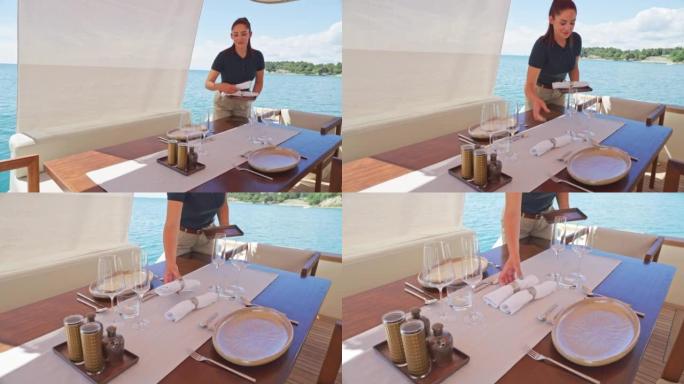 SLO MO DS空姐在游艇上准备餐桌