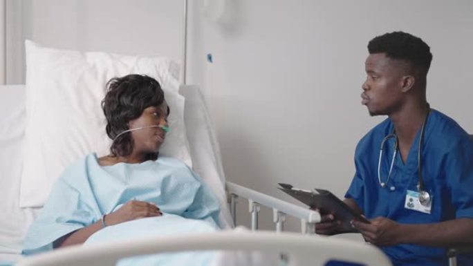 一位年轻的非裔美国男医生正在与患者交谈。一名黑人妇女患者与医生交谈