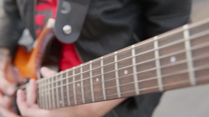 相机拍摄视频电吉他的指板，最后，音乐家与调解员演奏和弦。人用电吉他演奏。吉他琴弦上的手指。
