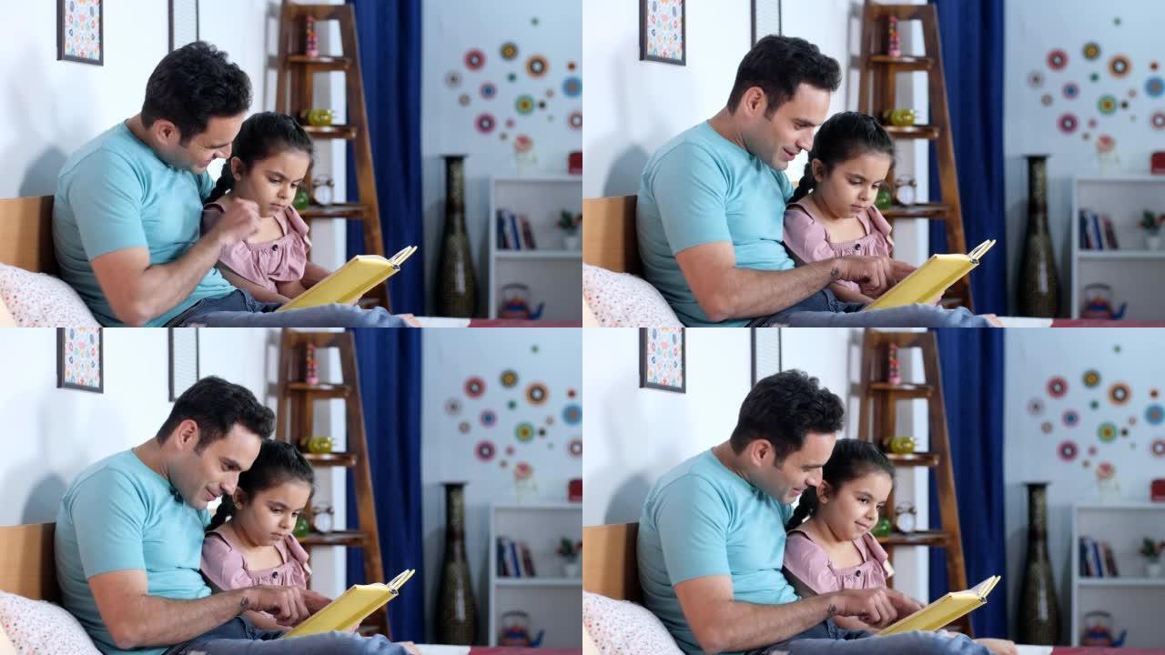 一位年轻的印度父亲和他的小女儿正在读书-夜间故事，就寝时间，过去最喜欢的时间，孩子的教育