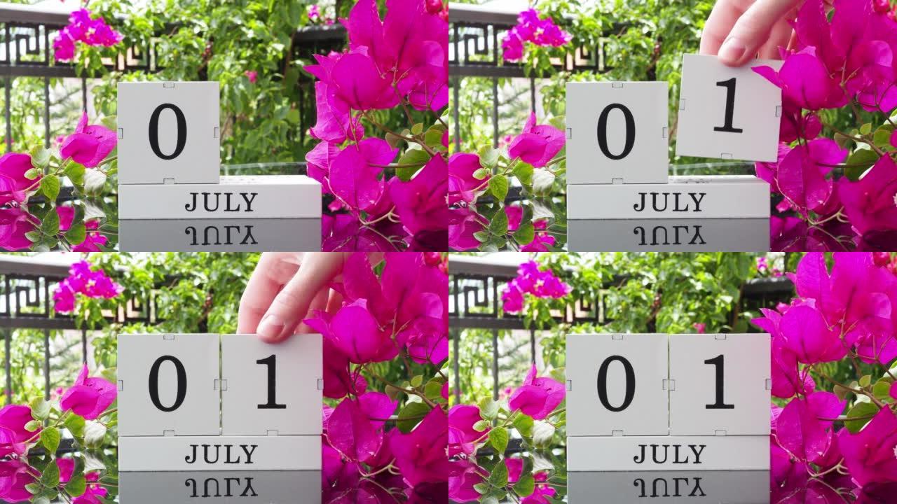 一个木制日历，有一个重要的活动，7月1日在一张有芙蓉花的桌子上，女人的手在日历上设定了日期。将日历翻