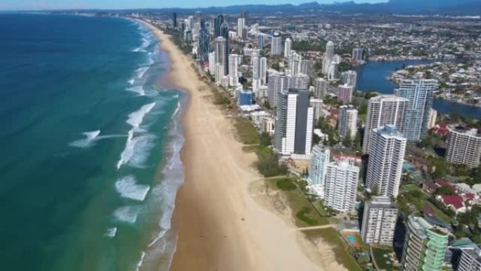 空中无人机回撤在昆士兰州黄金海岸冲浪者天堂的标志性黄金海岸海滩上方的反向视图