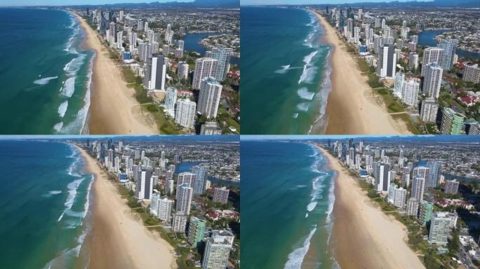 空中无人机回撤在昆士兰州黄金海岸冲浪者天堂的标志性黄金海岸海滩上方的反向视图
