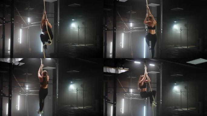 运动锻炼耐力和力量，女人在健身馆攀爬绳索