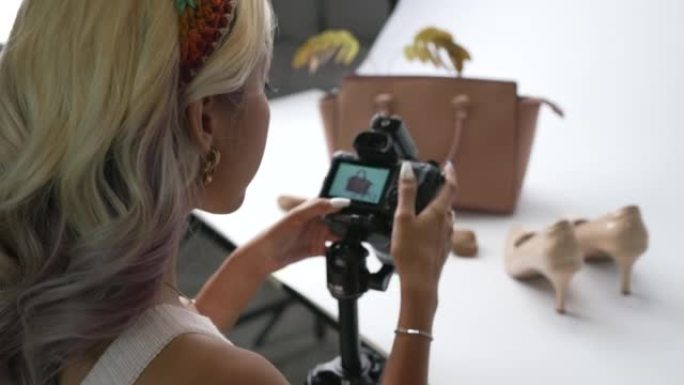 亚洲女性时装设计师，有影响力的人，博客作者或视频记录器准备使用相机拍摄时尚照片和产品直播。社交媒体概