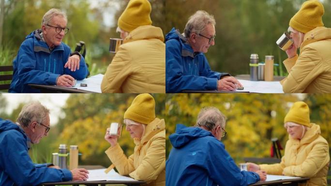 老年夫妇看着地图，从北欧人散步和在公园餐桌上喝茶休息