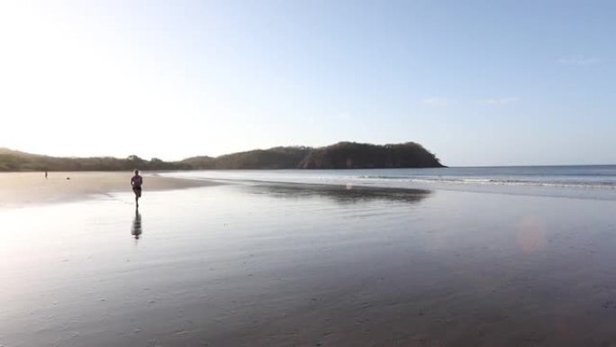 年轻女子沿着空旷的海滩奔跑，穿过浅滩