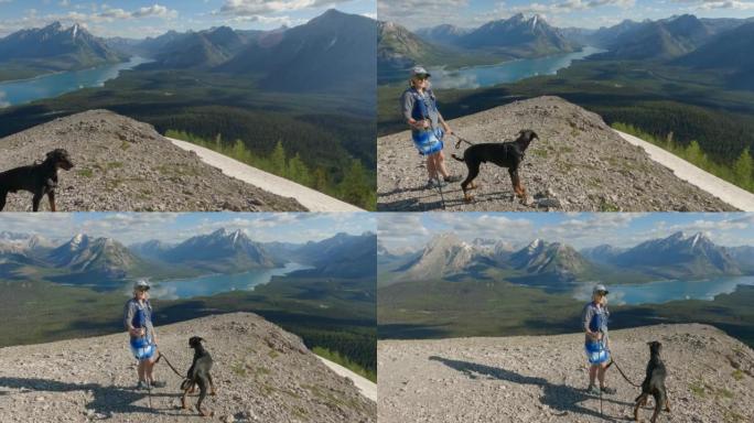 女性徒步旅行者和宠物狗接近山顶