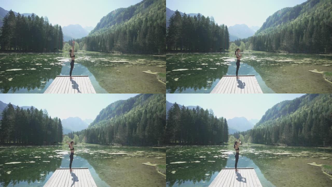 年轻女子在山和林景湖的码头尽头做瑜伽
