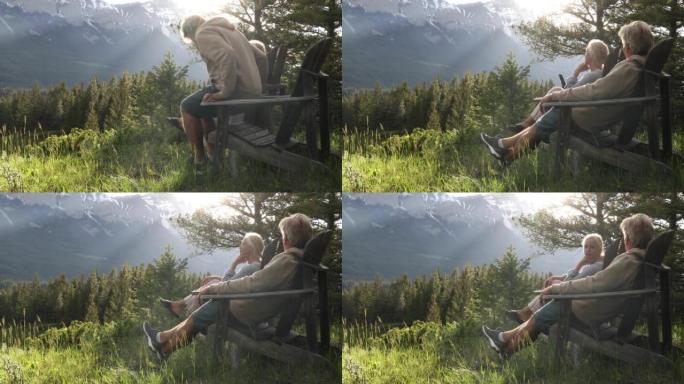 夫妇在木椅上放松，看着森林，山脉