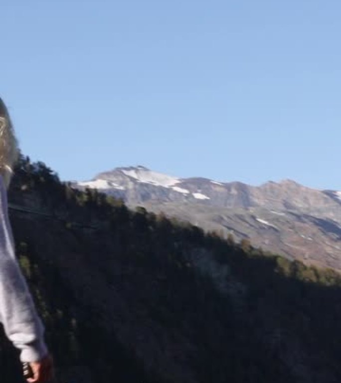 女人穿越山脊，拍摄智能手机照片