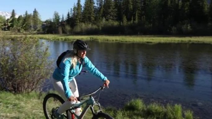 沿着山溪边缘的女人骑自行车
