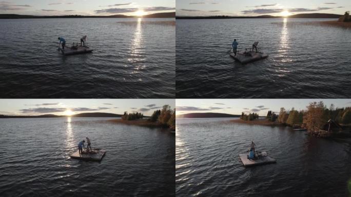 空中无人机拍摄了一男一女在湖上的浮动码头上划桨的镜头