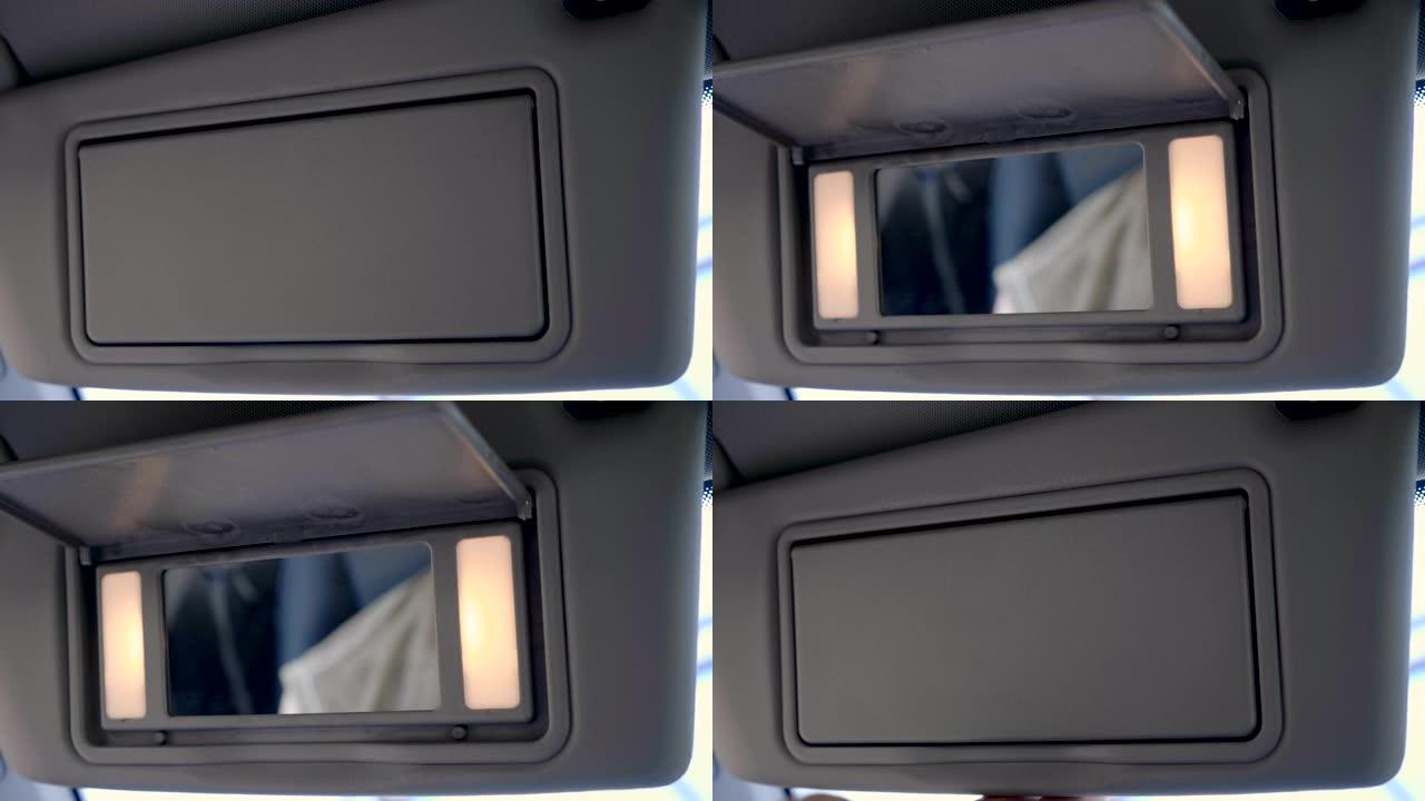 在汽车中，手拉下遮阳板，它还带有照明镜