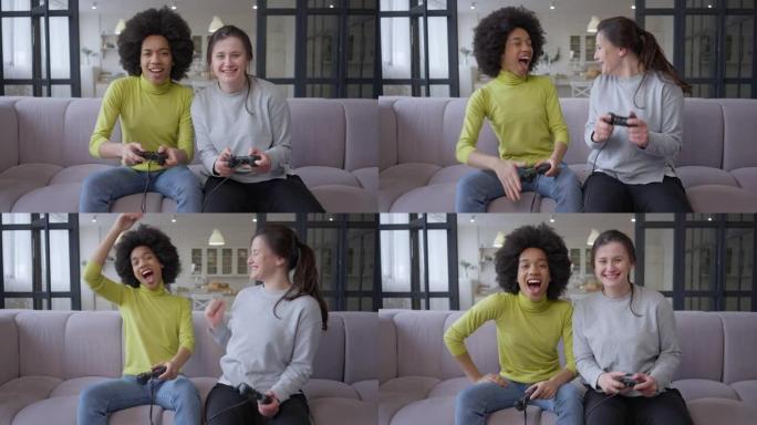 年轻快乐的女性游戏玩家给高五玩多人视频游戏的肖像。快乐无忧无虑的高加索人和非洲裔美国朋友坐在室内的沙