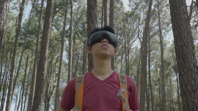在松林环境中使用虚拟现实眼镜移动头部的旅行者肖像。人与元宇宙小玩意概念