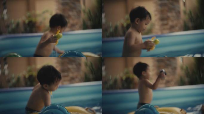 蹒跚学步的男孩在家里的游泳池里放松和父亲玩耍
