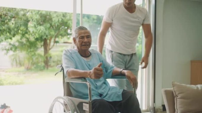 年轻人推着年迈的父亲坐在轮椅上