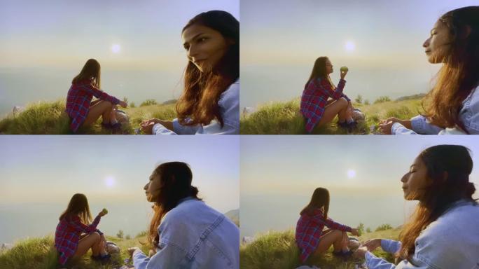 POV与两个女性远足朋友在阳光明媚的山顶上休息