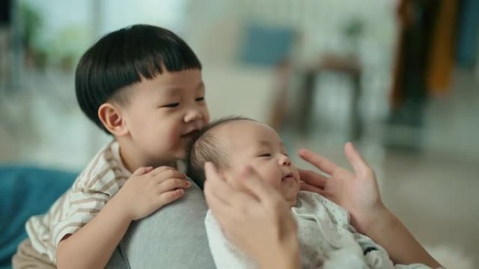 亚洲母亲与她的两个男婴蹒跚学步的孩子在家里交往时间