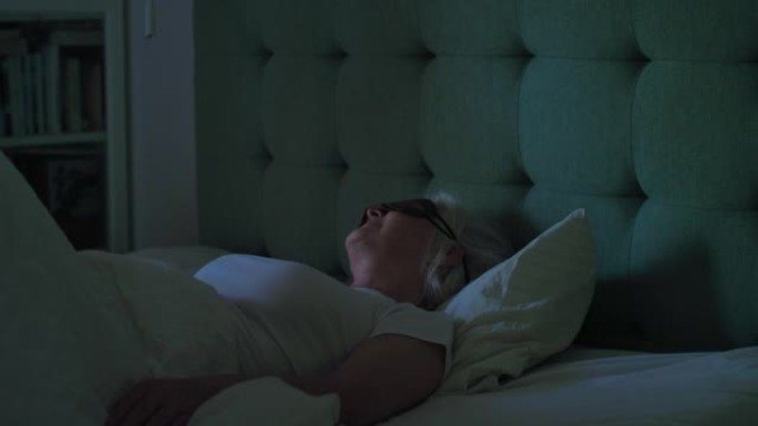 熟女睡前戴上眼罩。享受黑暗宁静的睡眠环境