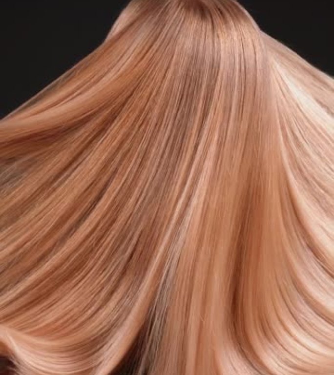 深色背景上美丽诱人的金发女人。扔头发，挥舞着明亮的金色健康头发。超级慢动作