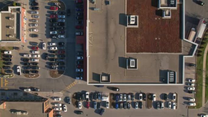 杂货店广场，超市或购物中心停车场的空中几何俯视图，有许多汽车进出。延时或超延时。