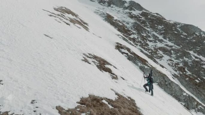 两名滑雪者在雪山上徒步旅行的空中无人机拍摄