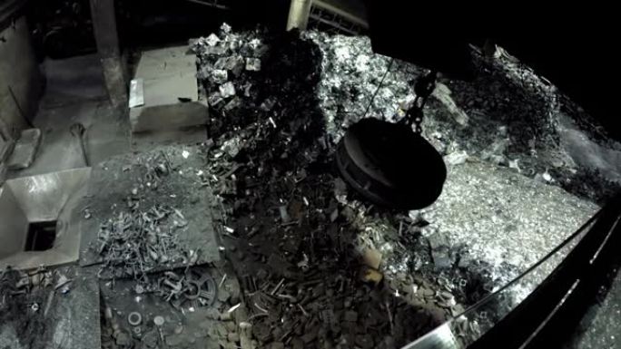 工业磁铁在晚上捡起废金属并将负载释放到切碎机中