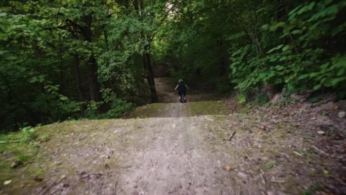 森林中的极限骑行，年轻的骑车人在土路上高速行驶