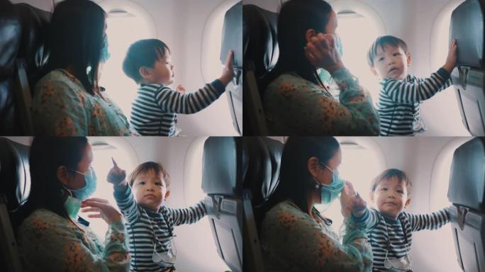 母亲和蹒跚学步的男孩一起坐飞机