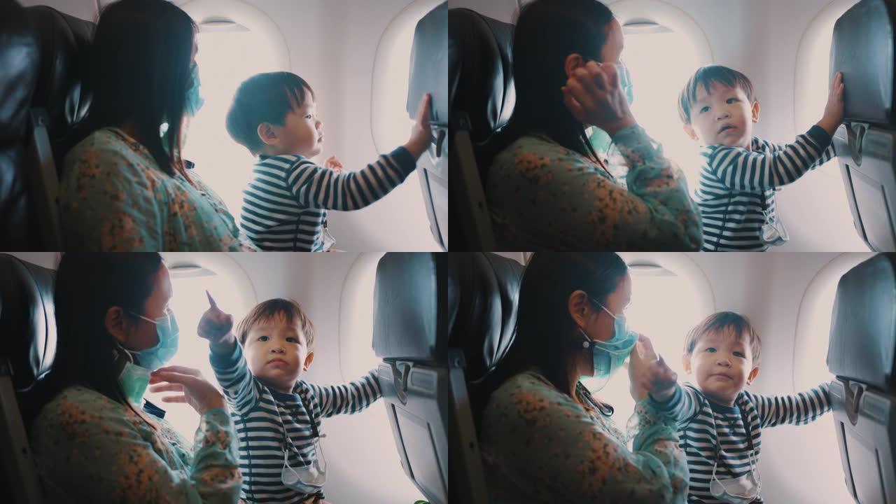 母亲和蹒跚学步的男孩一起坐飞机