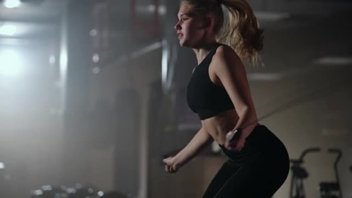 年轻的运动女子正在健身房跳绳，训练身体耐力，呼吸困难