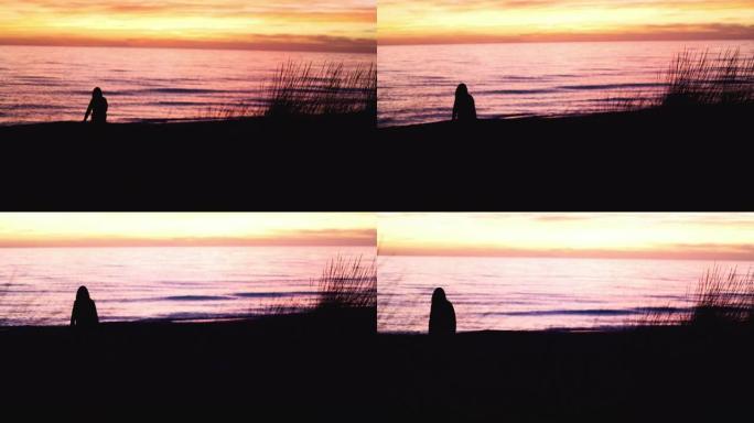 海滩上的女人剪影: 冬天的海洋日落