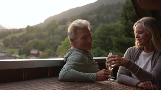 夫妇从山间阳台欣赏风景和饮料
