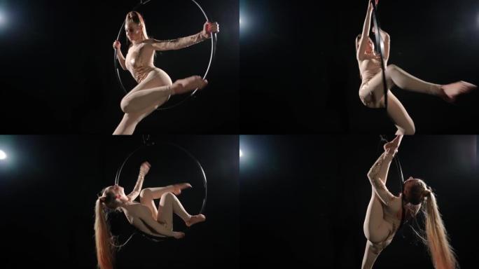 自信苗条的女人在黑色背景的空气箍上表演，背光。灵活的高加索空中体操运动员在舞台上弯曲分裂的飞行舞蹈。
