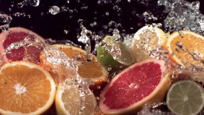 慢动作拍摄柑橘类水果和水溅过柠檬，酸橙，葡萄柚片