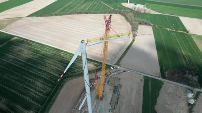 在施工过程中产生电力的风车，起重机提升风车的叶片。